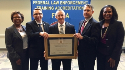 Members from the Drug Enforcement Administration receive their certificate for initial Program Accreditation