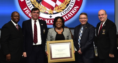 DEA Academy staff holding the FLETA accreditation certificate