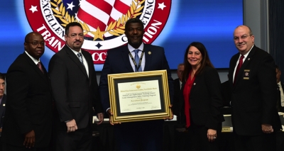 FLETC staff holding the FLETA accreditation certificate