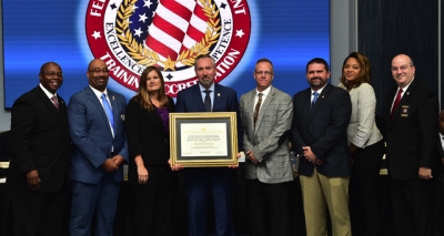 Naval Criminal Investigative Service staff holding the FLETA accreditation certificate