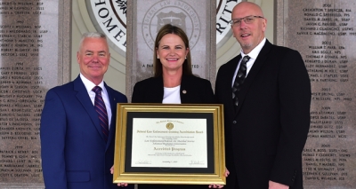 Transportation Security Administration staff holding the FLETA accreditation certificate