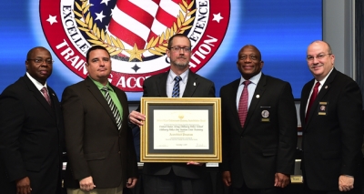 U.S. Army Military Police School staff holding the FLETA accreditation certificate