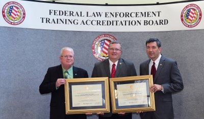 USAMPS staff accept the certificates of accreditation.