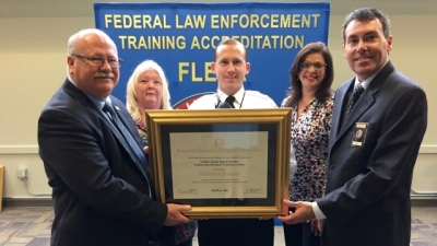 Members of the United States Secret Service accept their certificate of accreditation from Dr. Gary Mitchell and FLETA Board Chair Brian Peters